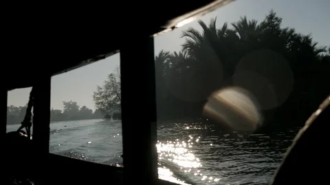 Sun flare and tropical trees on the riverbank, view from the moving motor boat Stock Footage 123161605