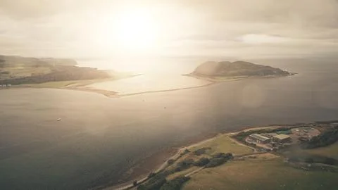 Sun flare at ocean bay reflection aerial. Seascape at mountainous islands at Fotos Stock