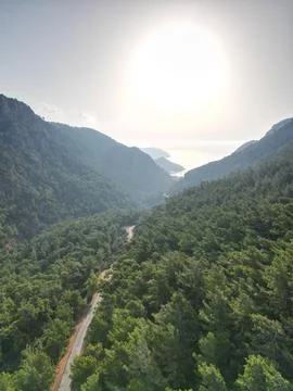 Sun Flare Over a Green Valley Leading to the Sea Stock Photos
