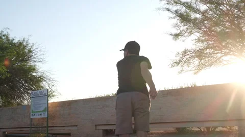 Sun flare shot of a man teeing off in disc golf Stock Footage 246826549