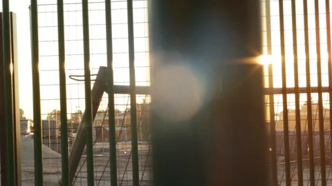 Sun flare trough gates at sunset 스톡 동영상 127692505