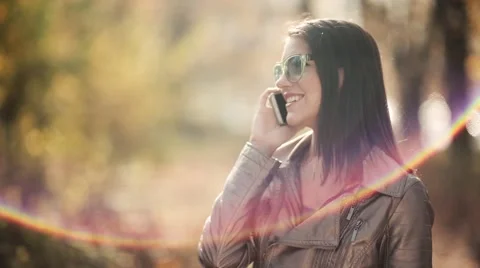Sun flare while woman talking on the phone 库存影片 43692140