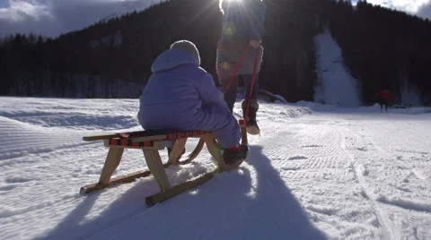 Sun Flared Slow Motion Of Mother Pulling Her Son On Sledge Stock Footage 45306310