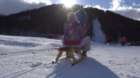Sun Flared Slow Motion Of Mother Pulling Her Daughter On Sledge Stock Footage 45306322