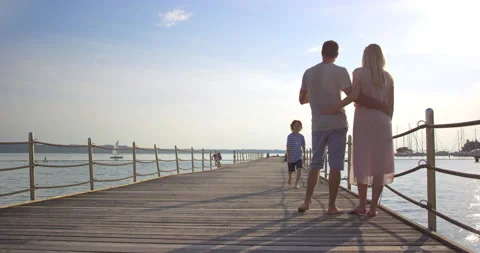 Sun Flared Of Son Walking To His Parents On Pier Stock Footage 144261302