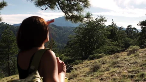 Sun flares and hand-held close up of woman with a backpack on a mountain top Stock Footage 138477024