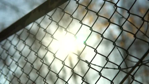 Sun flares through the cobweb. Secured area chainlink. Stock Footage 150262059