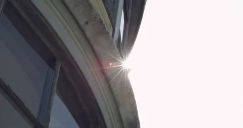 Sun flaring behind an industrial building Video stock 230454975