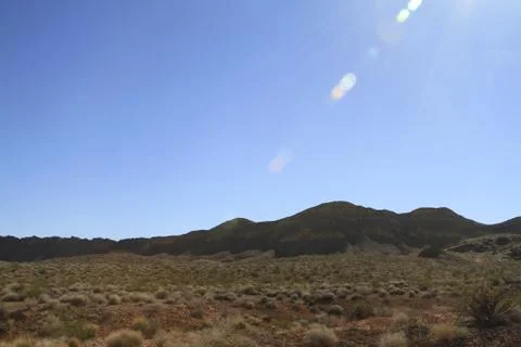 Sun flaring down over the nevada desert wasteland Stock Photos
