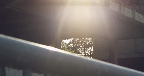 Sun flaring in an industrial area with a rustic building Stock Footage 230458966