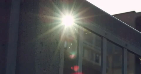 Sun flaring through a railing in an industrial area Stock Footage 230459727