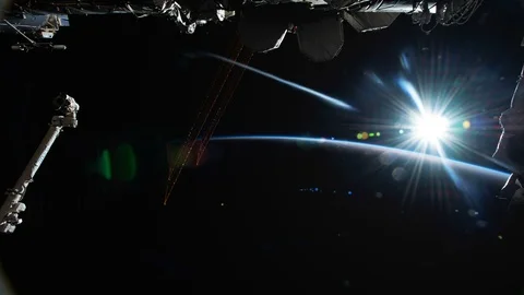 The Sun flows into view above the planet Earth as seen and filmed by astronauts. Stock Footage 104520973