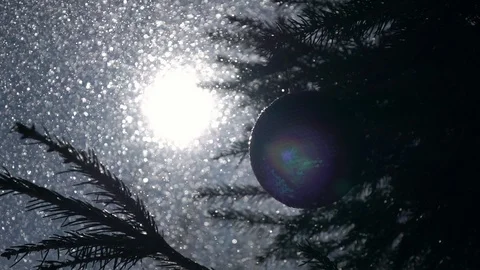 Sun in frame with lens flare and scaly Christmas tree ball in slow motion Stock Footage 87872294