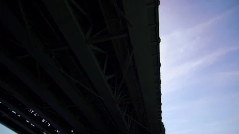 Sun glare appears from behind the bridge, the boat floats under the bridge Stock Footage 197741819