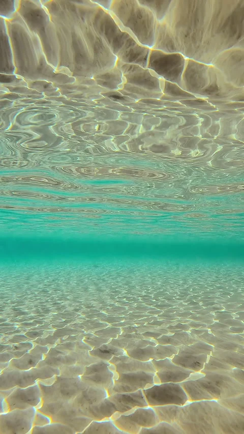 Sun glare on sand bottom reflecting in water surface, Slow motion Stock Footage 295486538