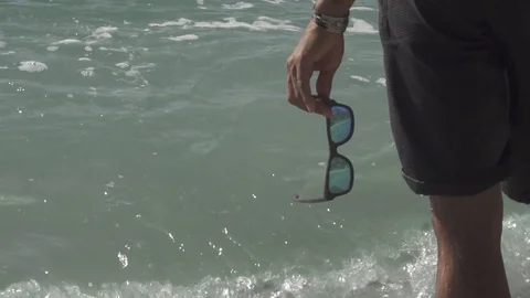 Sun Glasses and an Ocean Wave Slow Motion Stock Footage 106784898