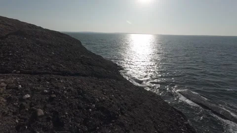 Sun glint on calm atlantic ocean surface viewed from coastal cliff Stock Footage 340462480