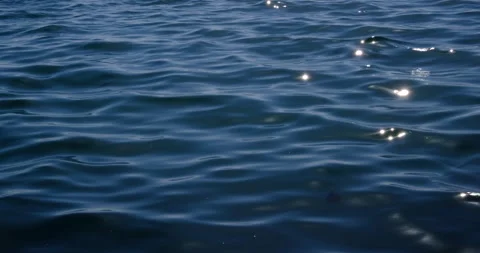 Sun glinting on soft ripples on surface of calm sea Stock Footage 131106408
