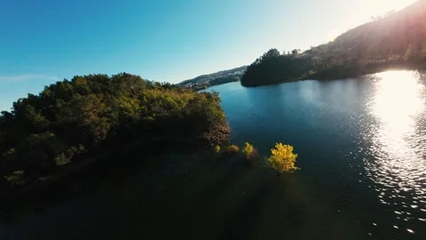 Sun glints off calm water, reflecting blue sky at Castelo de Bode Stock Footage 342271814