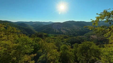 Sun glints through leaves as valley stretches below. Boracki krs Serbia 動画素材 345003787