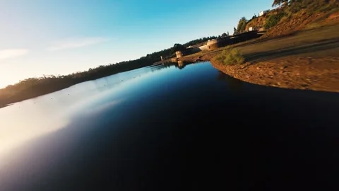 Sun glows low over calm lake surface at Pego do Altar Reservoir, Alcacer do Sal Stock Footage 342186049