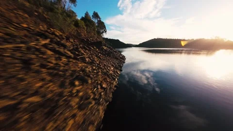 Sun glows low over calm lake surface at Pego do Altar Reservoir, Alcacer do Sal Stock Footage 342187869