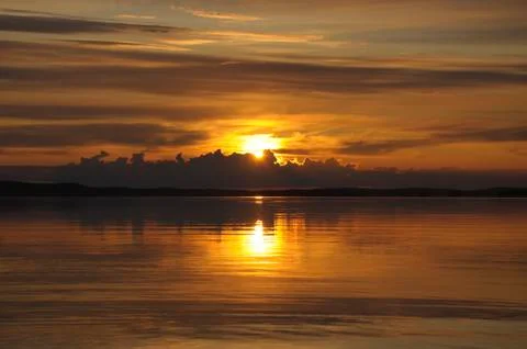 Sun goes down to the clouds Stock Photos