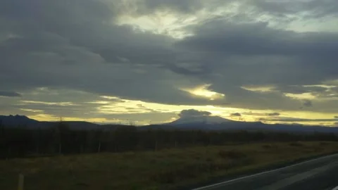 The sun goes down over the high snow-capped mountains. Sunset over a volcano Stock Footage 130445143