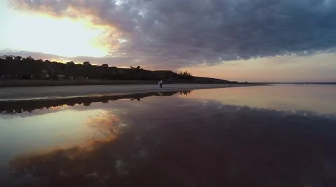 Sun goes down over pacific ocean and people get rest on sandy beach at autumn Видео 64970288