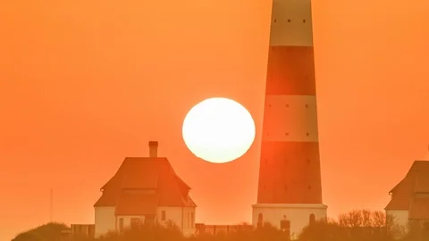 Sun going down near the lighthouse Westerheversand and keeper's cottages Stock Footage 87801684