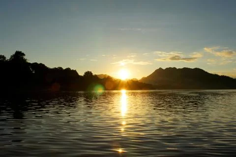 Sun going down over the mekong river with moutain behind Stock Photos