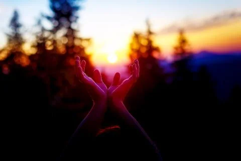 Sun in hands. Sunset on the background of raised hands. Foto stock