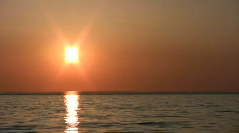 Sun hangs low and reflects in the water (High Definition) Stock Footage 360751
