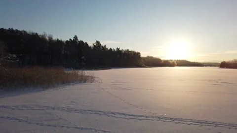 The sun has just risen and lights up a frozen lake Video stock 148932382