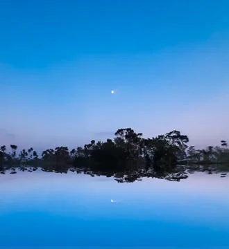 The sun has set in the evening and the moon has risen in the eastern sky. Sha Stock Photos