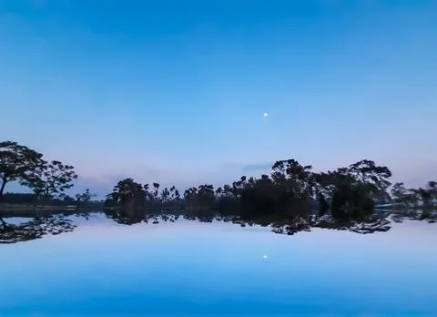 The sun has set in the evening and the moon has risen in the eastern sky. Sha Stock Photos