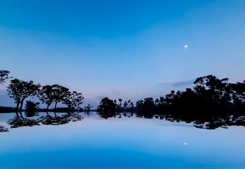 The sun has set in the evening and the moon has risen in the eastern sky. Sha Stock Photos
