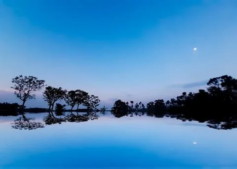 The sun has set in the evening and the moon has risen in the eastern sky. Sha Stock Photos