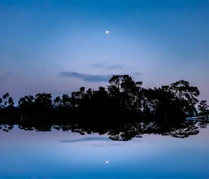 The sun has set in the evening and the moon has risen in the eastern sky. Sha Stock Photos