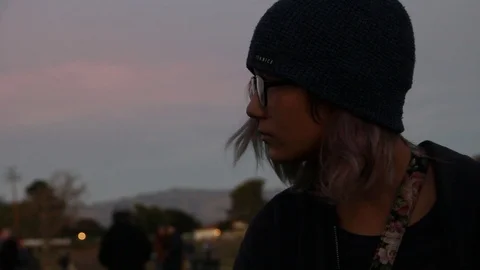 Sun has set on girl alone in the crowd Stock Footage 122356348