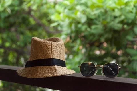 Sun hat and sunglasses on background with trees. Summer vacation at the inn.  스톡 사진