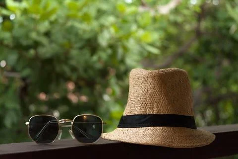 Sun hat and sunglasses on background with trees. Summer vacation at the inn.  스톡 사진