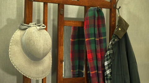 A sun hat being thrown onto the hook of an old wooden stand. Video stock 238019760