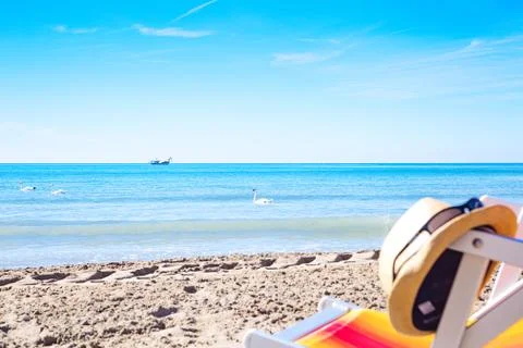 Sun hat on the deck chair on the beach Stock Photos