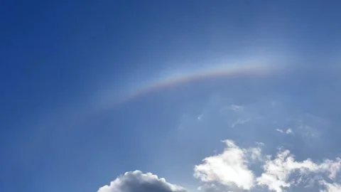Sun hidden behind cloud with rainbow colored atmospheric effect, sky Stock Footage 348959266