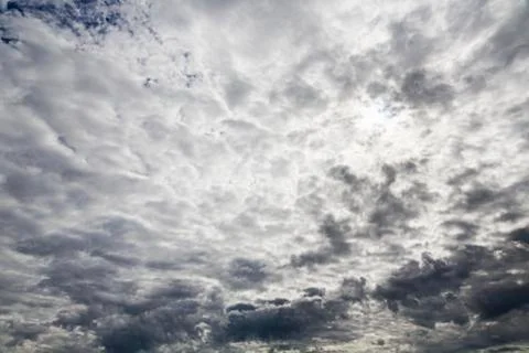 Sun hidden behind dramatic cloudscape Stock Photos