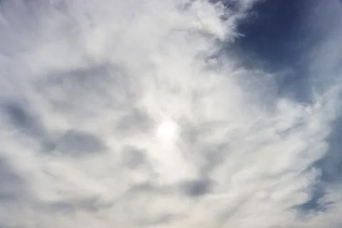 The sun is hidden behind gray clouds. Stock Photos