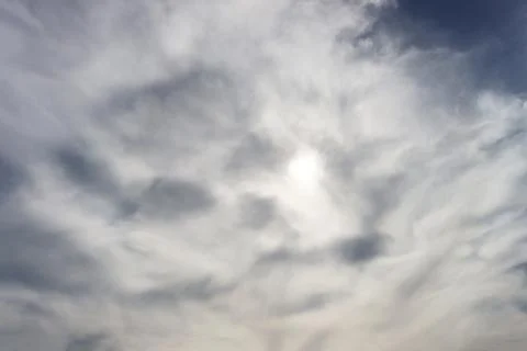 The sun is hidden behind gray clouds. Stock Photos