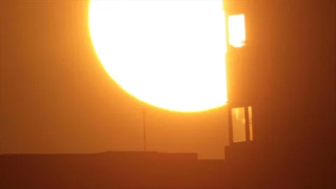 The sun is hiding behind a town skyscraper Stock Footage 161471736