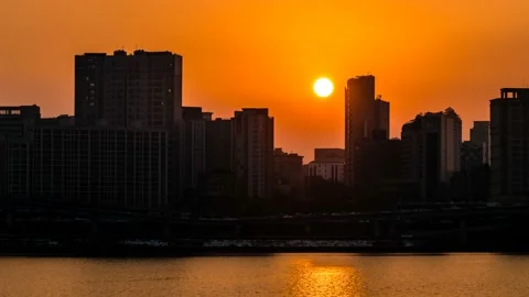 The sun is hiding between buildings and apartments in the city. time lapse. Vidéo 145889639
